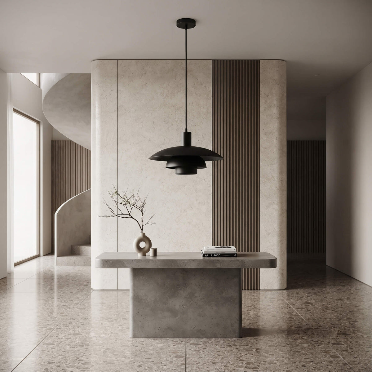A modern black pendant light with a layered, saucer-like shade hangs over a minimalist concrete console table in a contemporary interior with textured beige walls and wood slat accents.