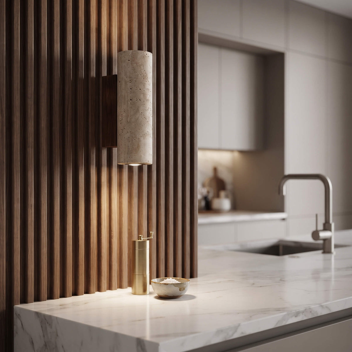 A modern cylindrical wall sconce with a textured beige stone or concrete finish and a warm wood-look mount, mounted on a slatted wooden kitchen wall above a marble countertop.