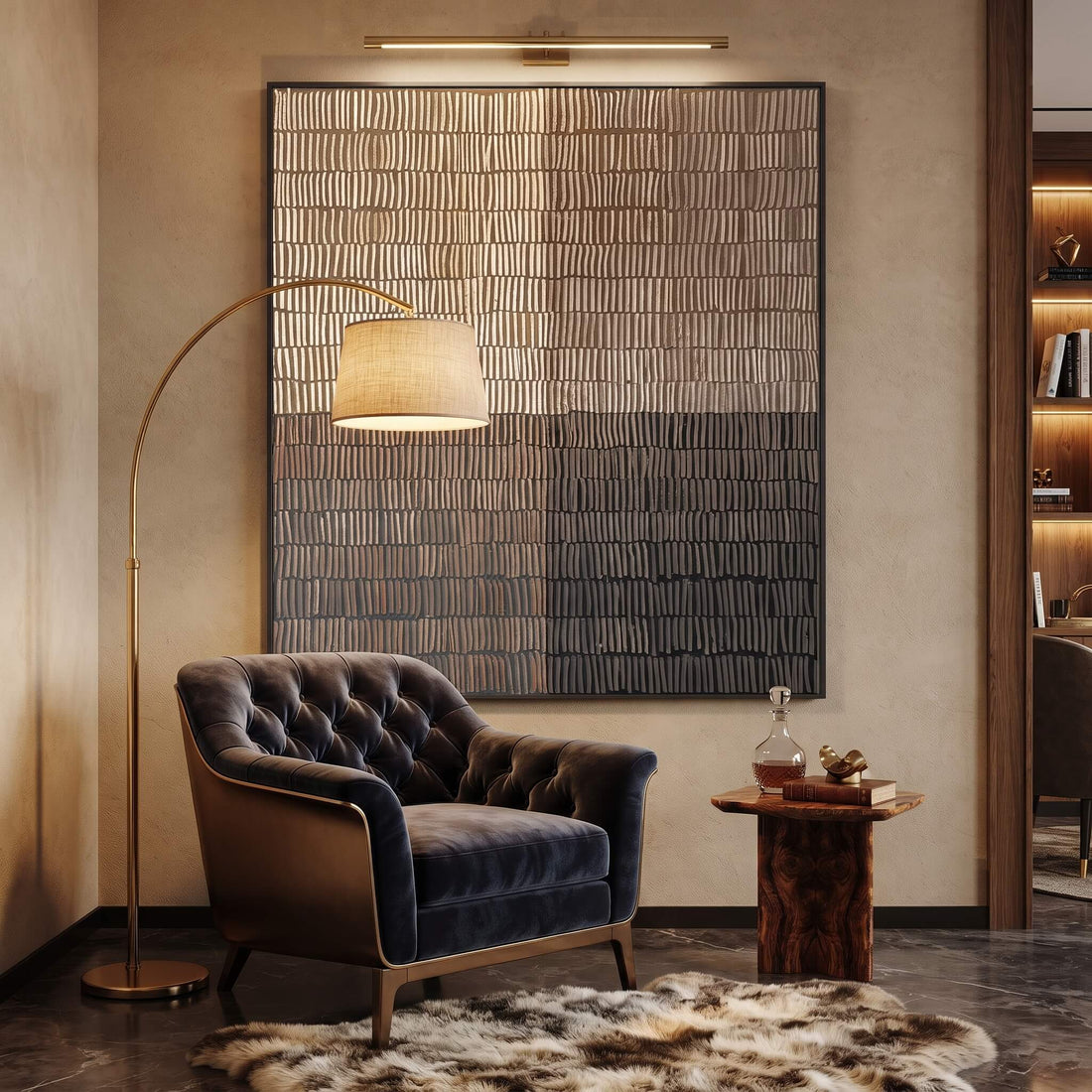 A modern living room corner featuring a large rectangular wall art piece with horizontal textured bands in beige, brown, and charcoal tones, above a tufted velvet armchair and a floor lamp.