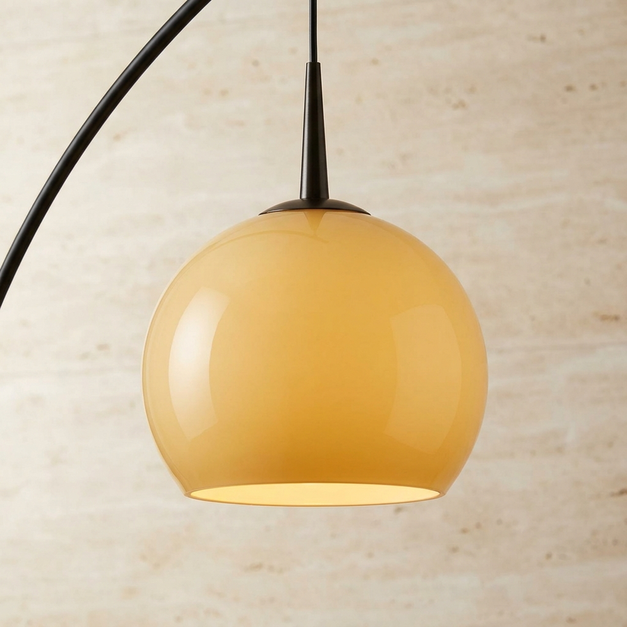 Close-up of the amber glass globe shade and black arc arm on the French Mid Century Arc Floor Lamp