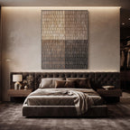 A modern bedroom featuring a low tufted platform bed in dark brown velvet, styled with matching brown bedding and pillows. The bed is centered beneath a large vertical abstract canvas art piece on a textured beige wall, flanked by matching wood nightstands with a lamp and decorative vase.
