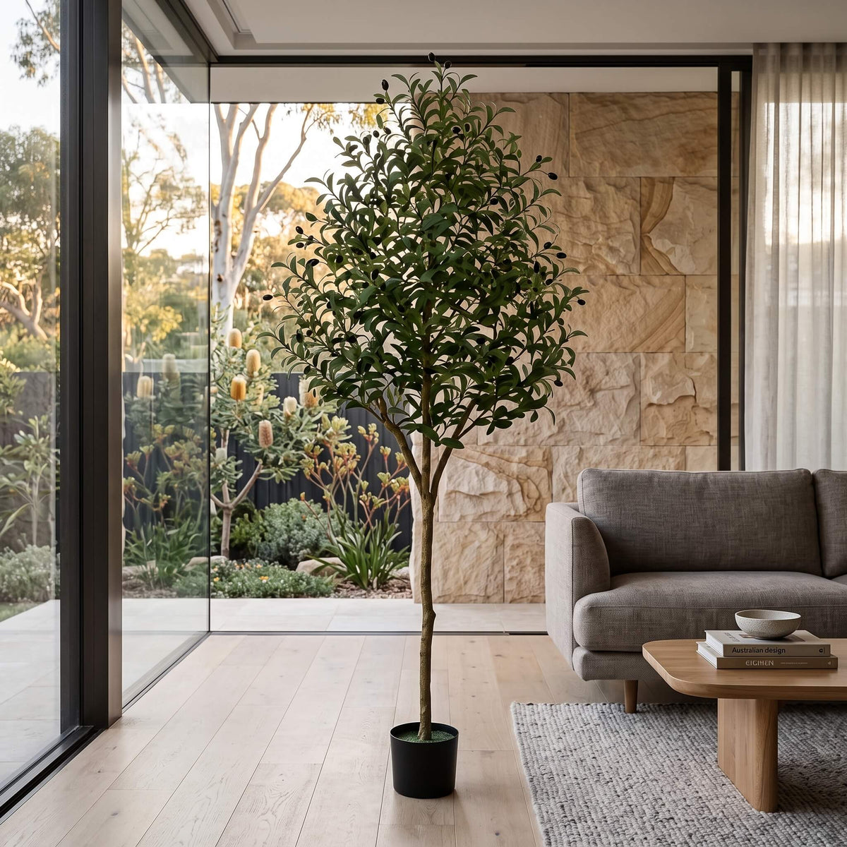 Large faux olive tree styled indoors in a bright room