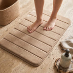 Beige memory foam bath mat in front of a shower