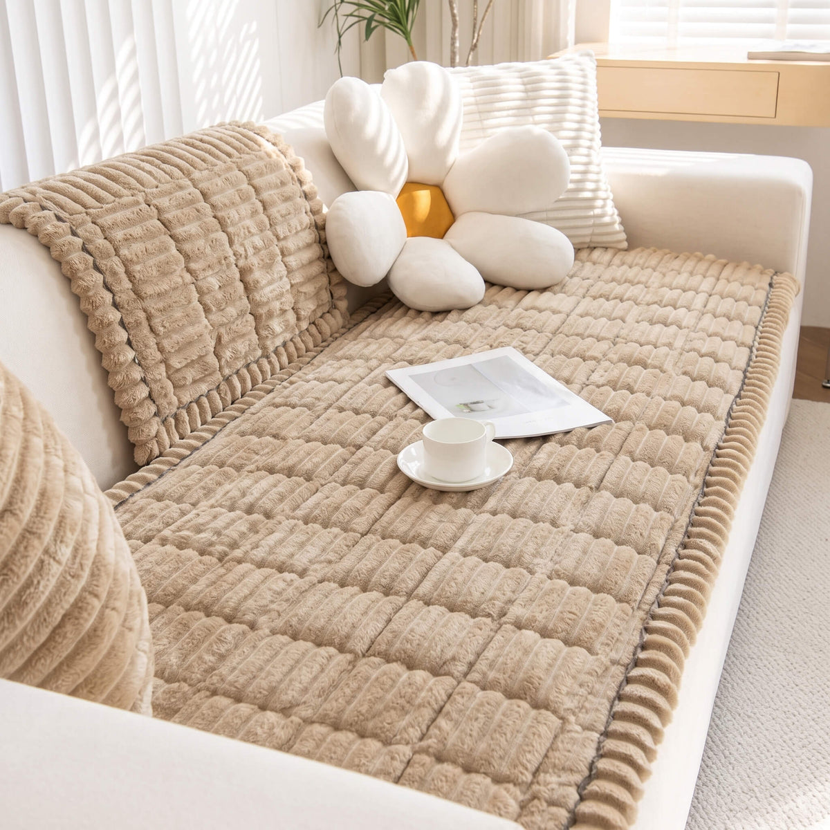 Beige plush pleated sofa cover with the ruffle edge over the cushion line