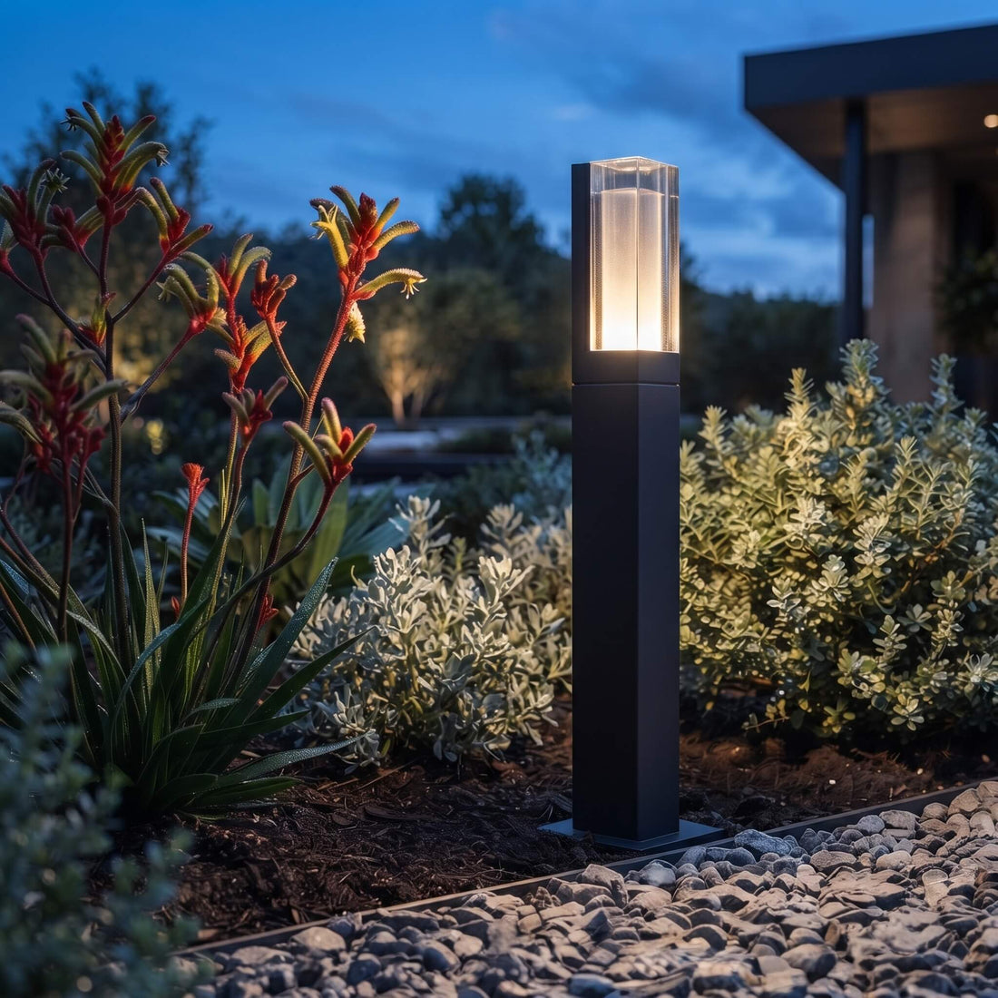 Matte black aluminium body of the Beacon bollard light in a garden bed