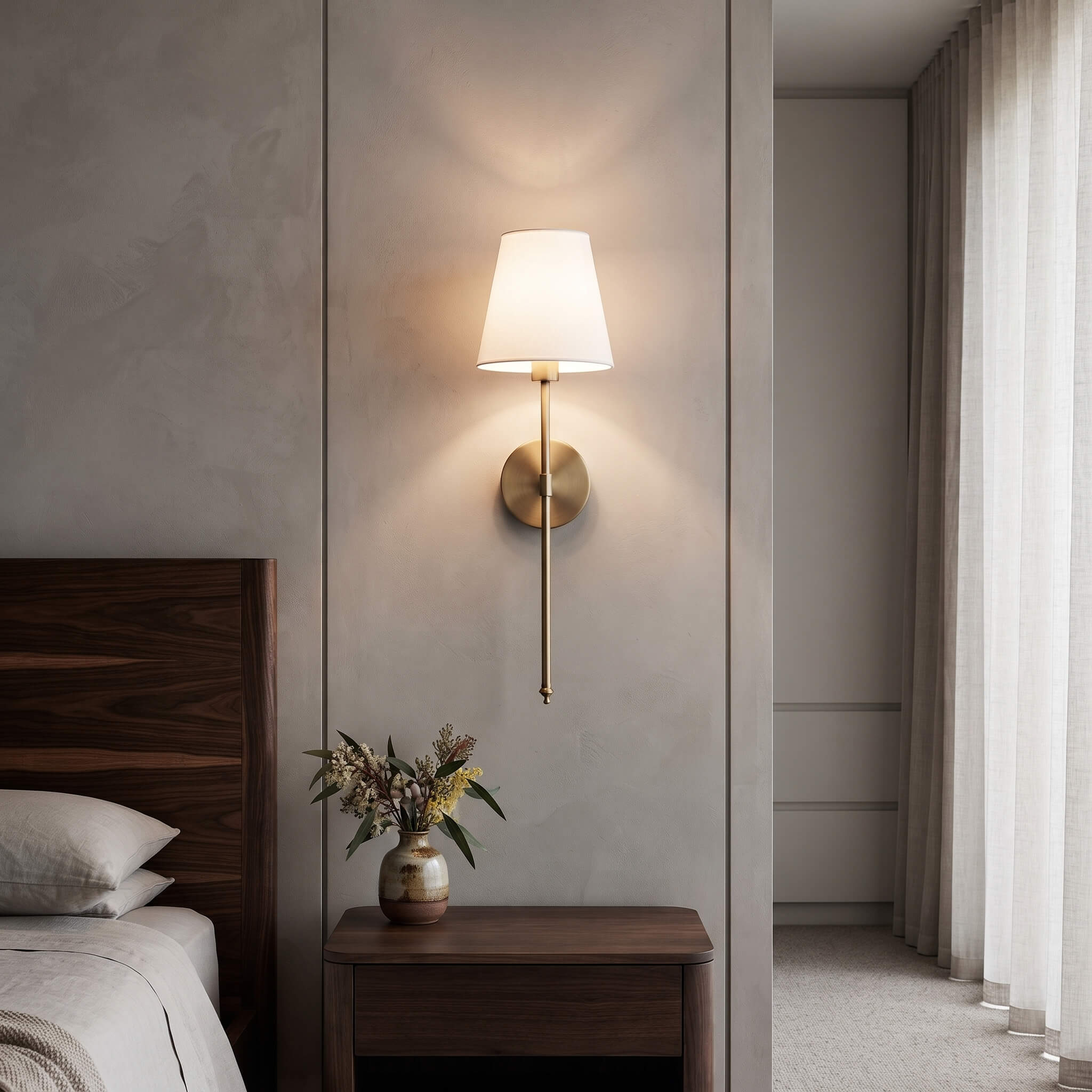 Brass wall sconce beside a walnut bed with a nightstand below