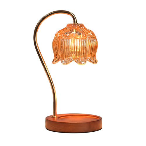 A modern table lamp with a curved metallic gold-finished stem, a ribbed amber-orange glass bell-shaped shade, and a round wooden base, shown against a plain white background.