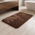 Chocolate brown plush bath rug on a tiled floor