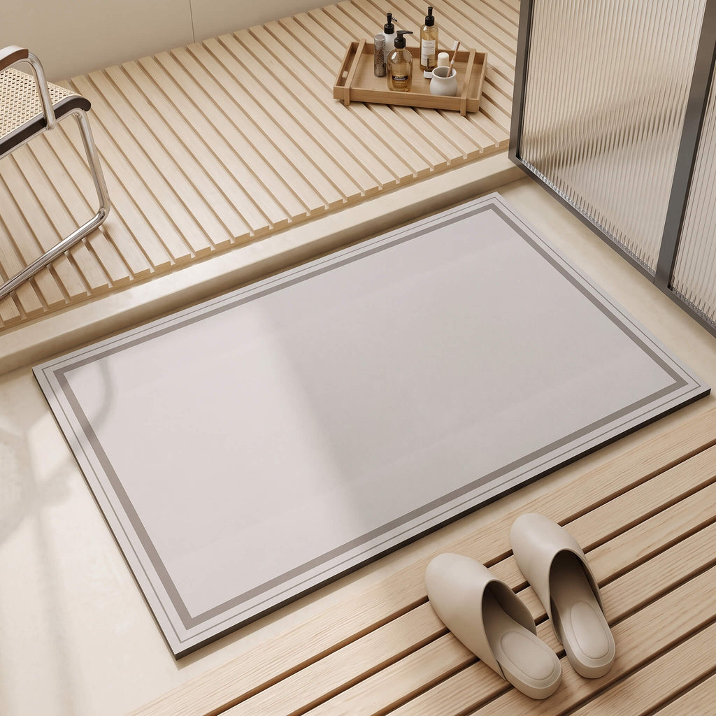 Frame pattern diatomite bath mat lying flat on bathroom tile