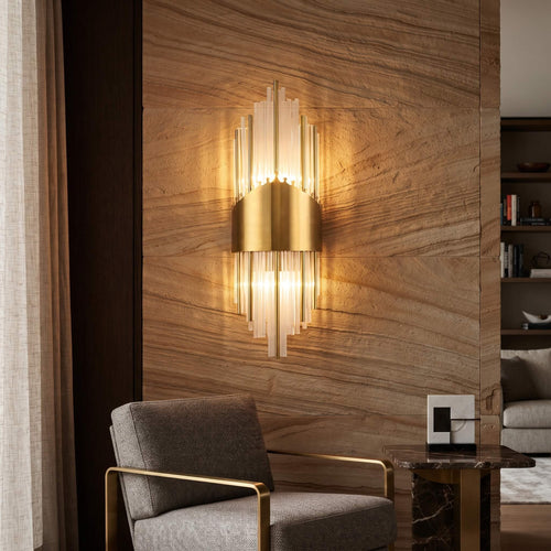 Art deco glass rod wall sconce lit against a sandstone feature wall