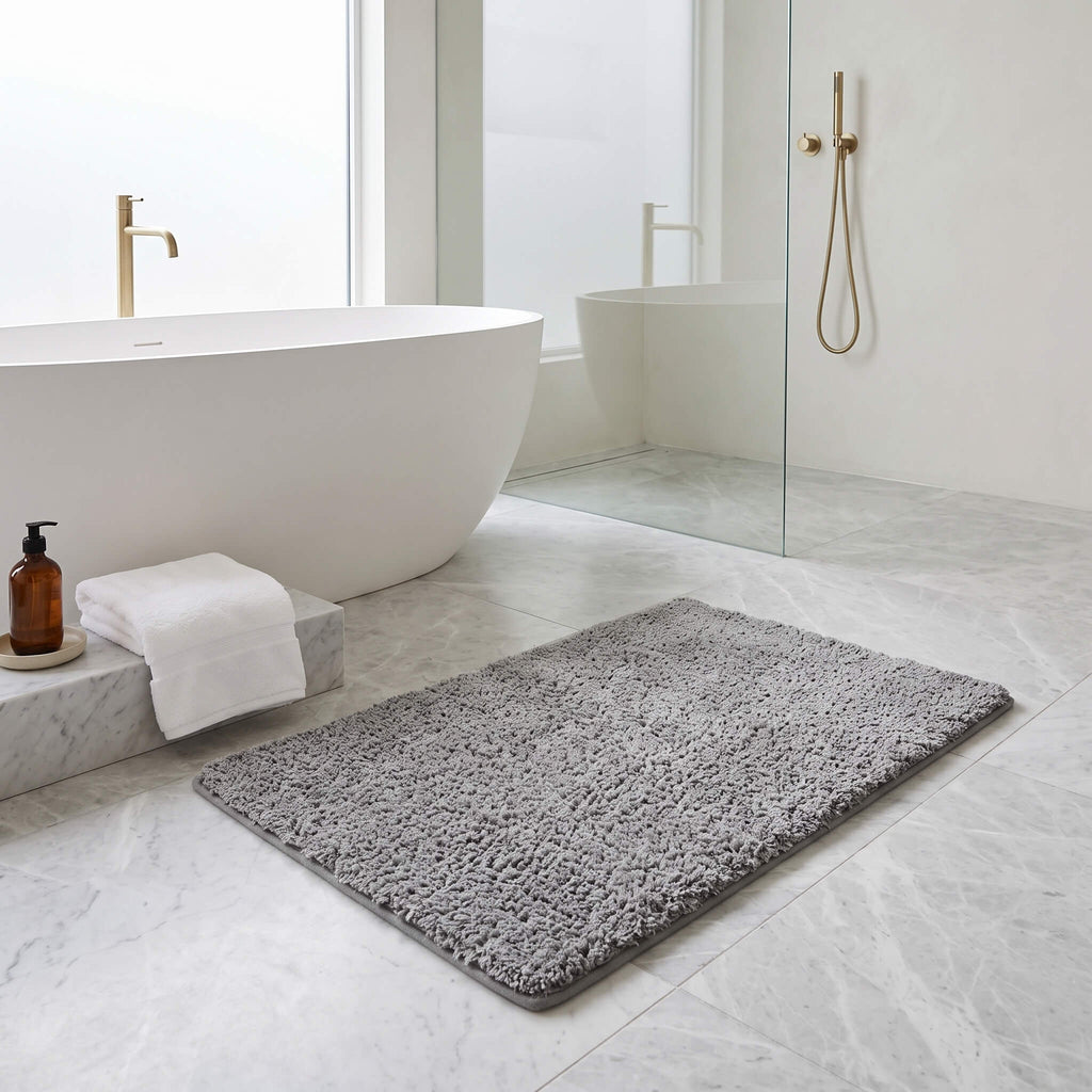Grey plush bath rug in a bathroom