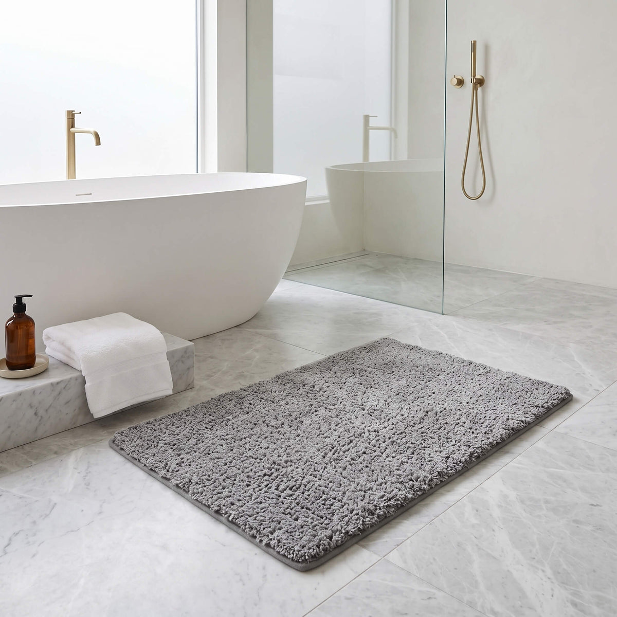 Grey plush bath rug in a bathroom
