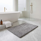 Grey plush bath rug in a bathroom