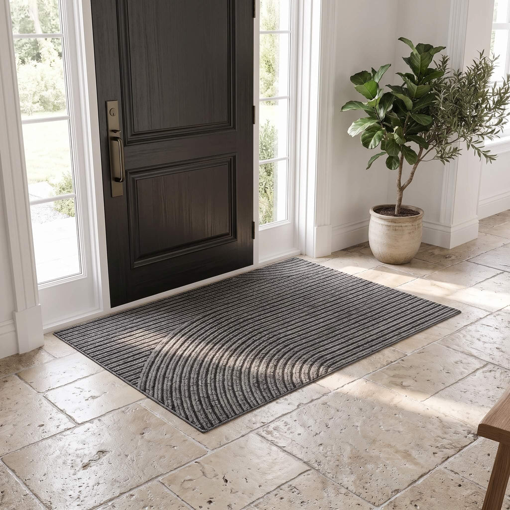 Grey ribbed non slip door mat at a front entrance on travertine tile
