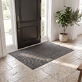 Grey ribbed non slip door mat at a front entrance on travertine tile