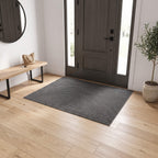 Grey ribbed door mat sitting low against the door it clears
