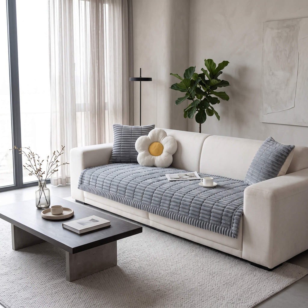 Grey plush pleated sofa cover across the seat of a light sofa