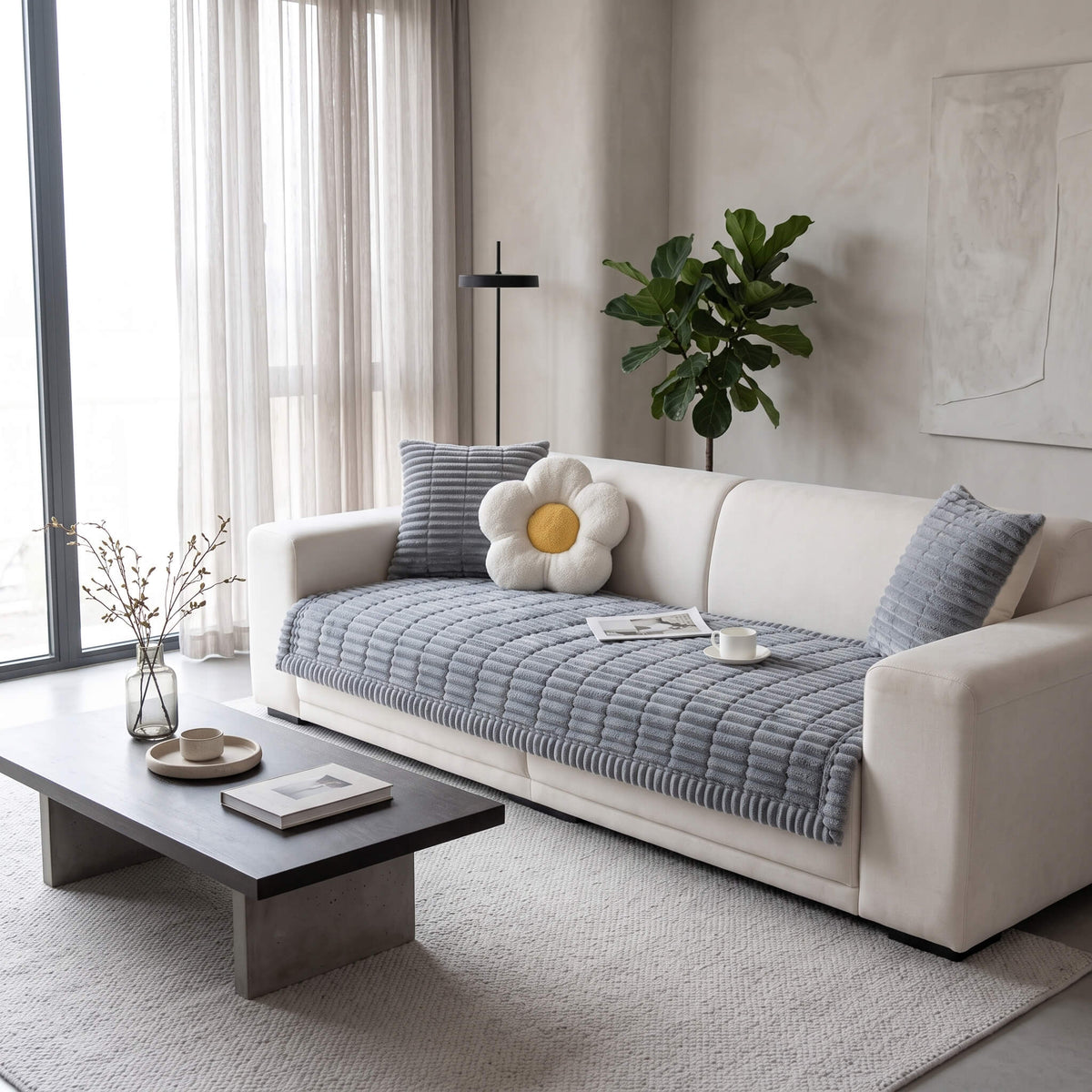 Grey plush pleated sofa cover across the seat of a light sofa