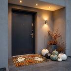 Pumpkins and Ghosts doormat at a dark apartment door in the evening