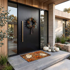 Pumpkins and Ghosts doormat lying flat on slate at a black pivot door