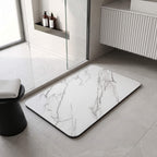 Marble look bath mat laid flat beside a vanity