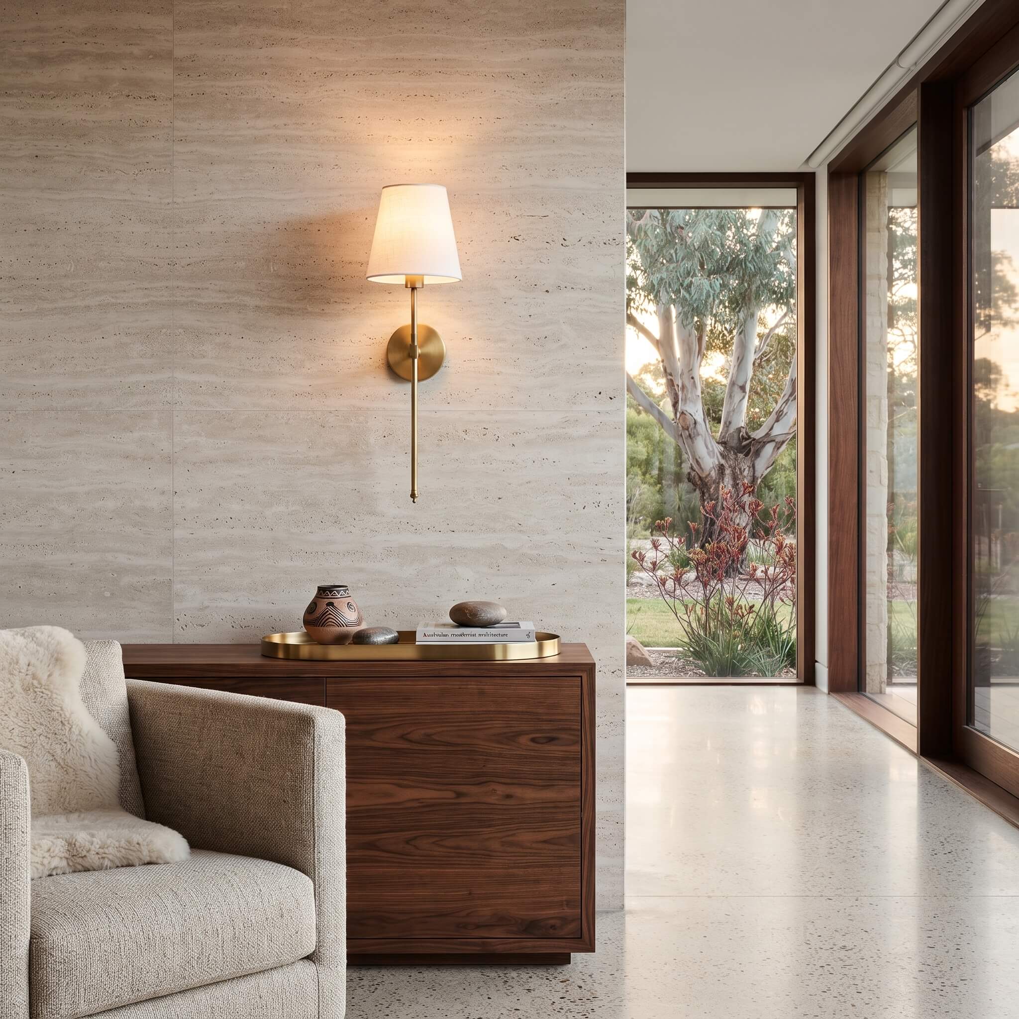 Brass wall sconce above a walnut credenza in an Australian home