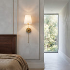 Brass finish stem and tapered shade on a panelled bedroom wall