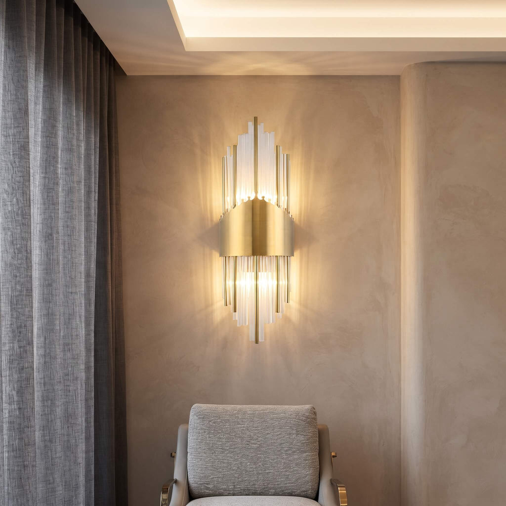 Art deco glass rod sconce glowing in a plaster corner at night