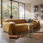 Mustard sofa cover throw in a living room with a gallery wall