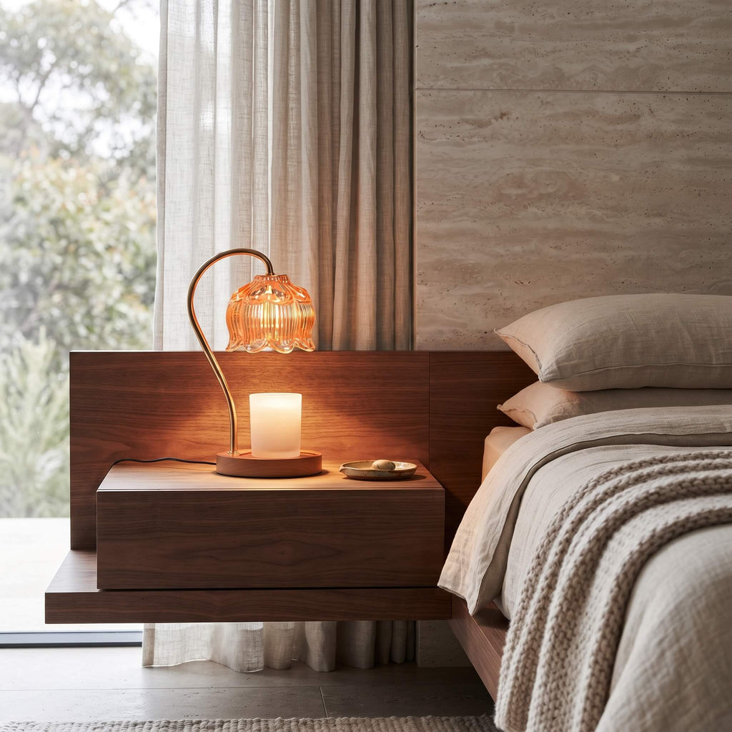 Amber glass candle warmer lamp on a bedside table