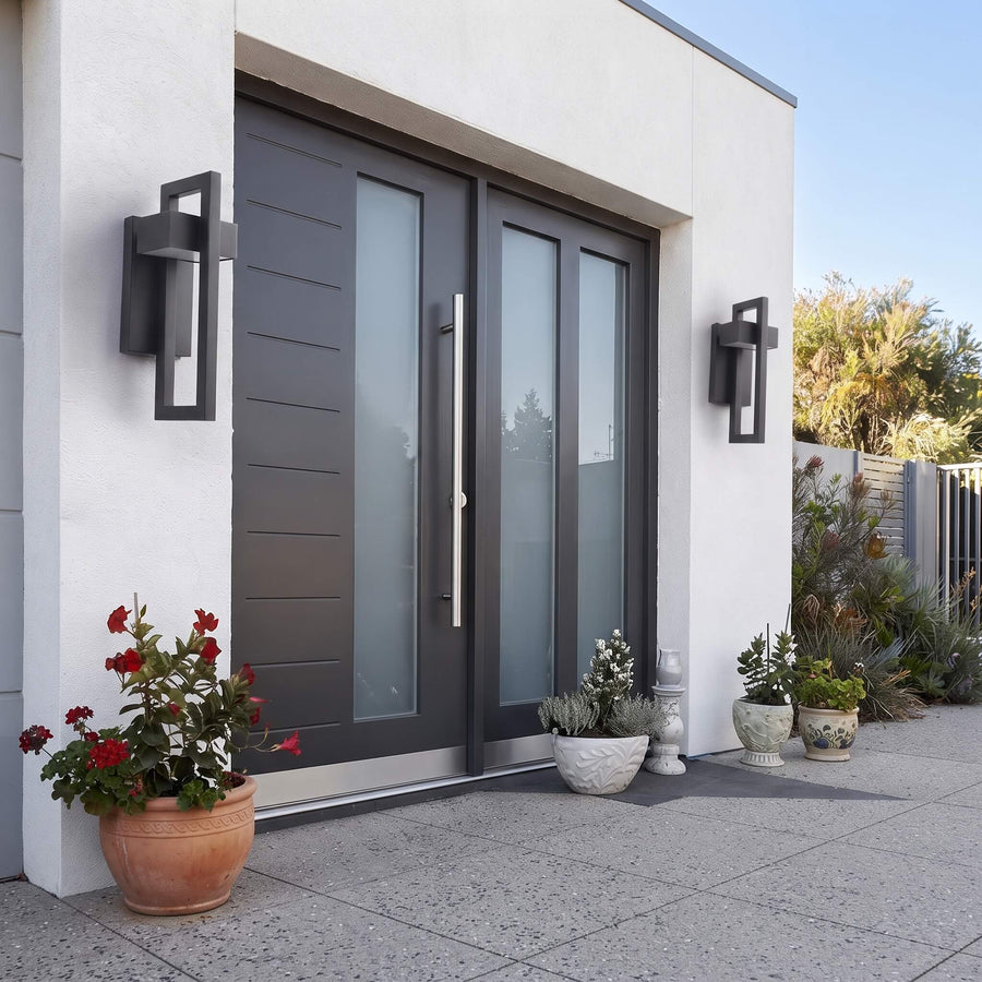 The IP65 rated Modern Hollow Outdoor Wall Light lit on an exterior wall