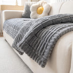 Grey plush sofa cover across a white sofa seat