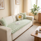 Sage green plush couch cover in a bright living room