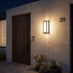 The Sentry wall light casting an even wash of warm light across an exterior wall