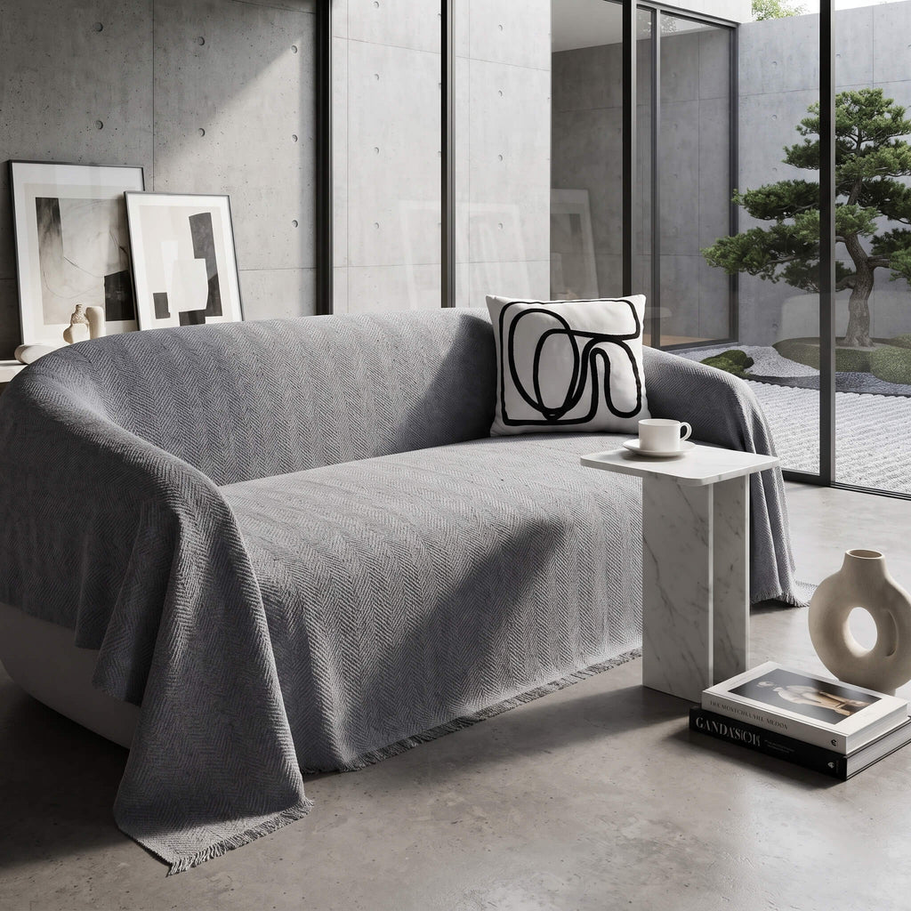 Grey sofa cover throw showing the fringed edge draping over the arm
