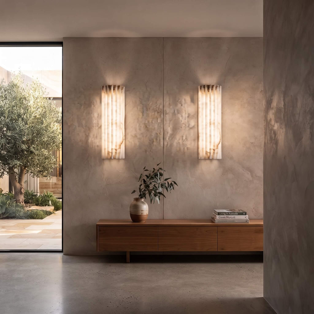 A flanking pair of alabaster wall sconces above a walnut credenza