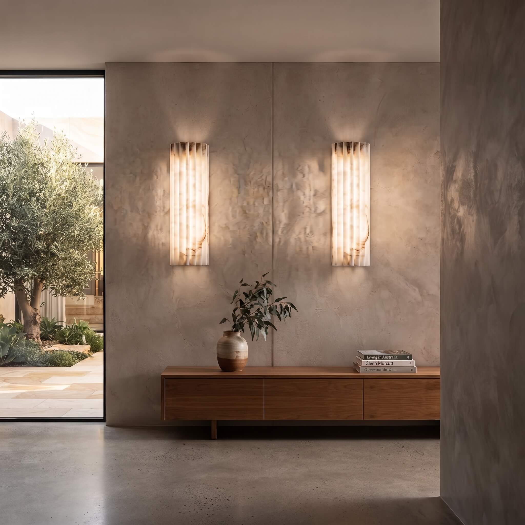 A flanking pair of alabaster wall sconces above a walnut credenza