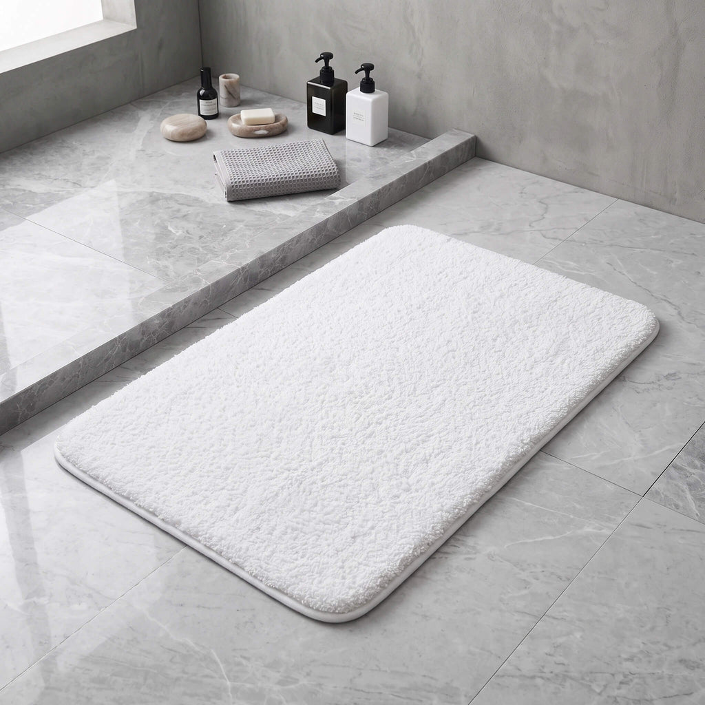 White plush bath rug in front of a shower