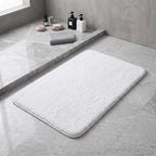 White plush bath rug in front of a shower