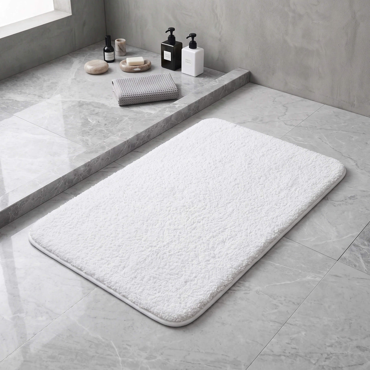 White plush bath rug in front of a shower