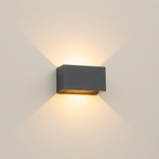 Matte black up and down wall light on a plain cream wall showing its twin beam pattern