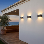 Row of three up down wall lights along a white alfresco wall at a coastal Australian home