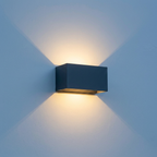 Aperture IP65 up down wall light mounted on a rendered exterior wall casting warm light above and below