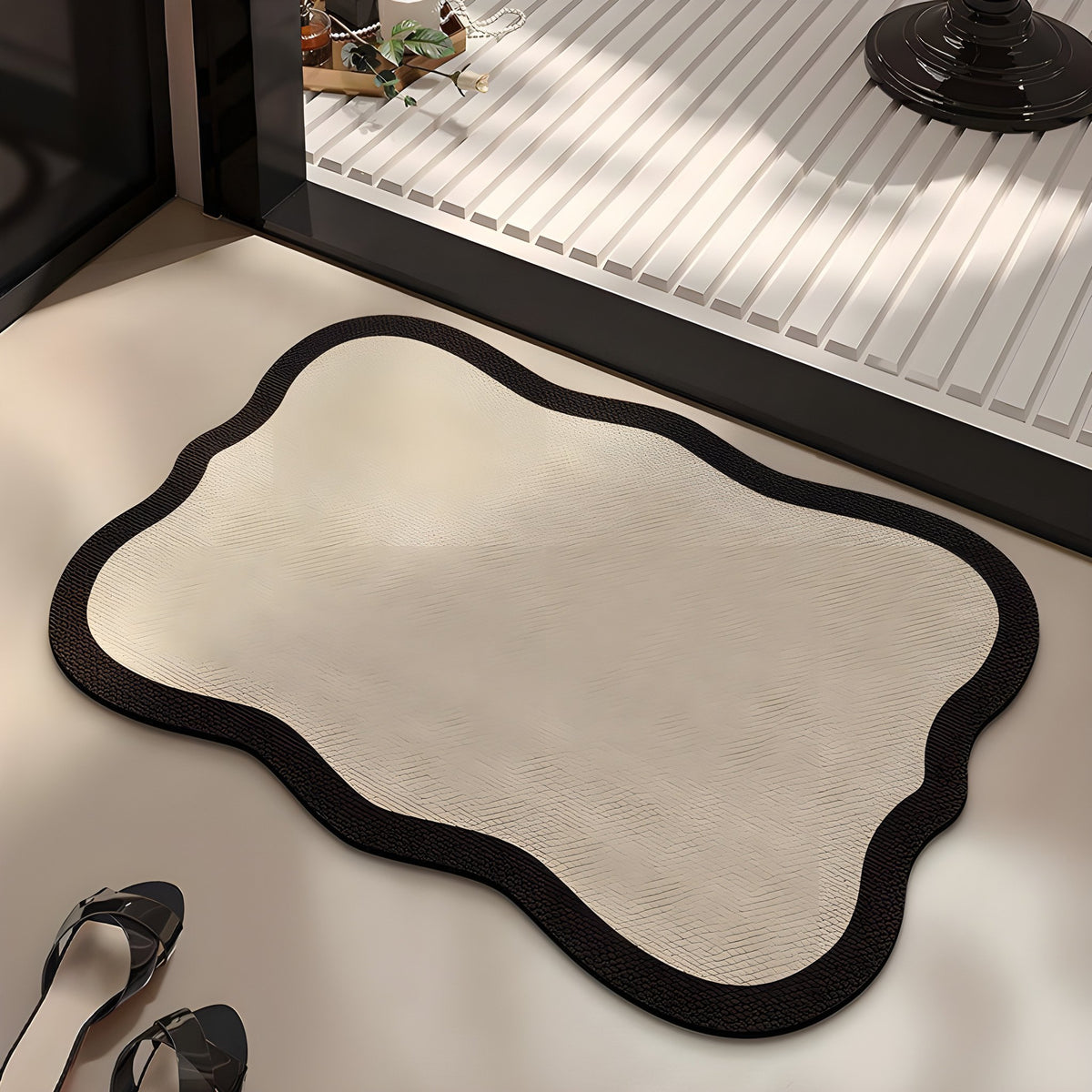 Ivory absorbent diatom mud bath mat, ivory centre with a dark wavy edge, on a bathroom floor