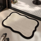 Ivory absorbent diatom mud bath mat, ivory centre with a dark wavy edge, on a bathroom floor