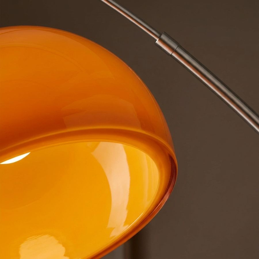 Close-up of the glowing orange acrylic dome shade and steel arm joint of the Bauhaus Arc Floor Lamp