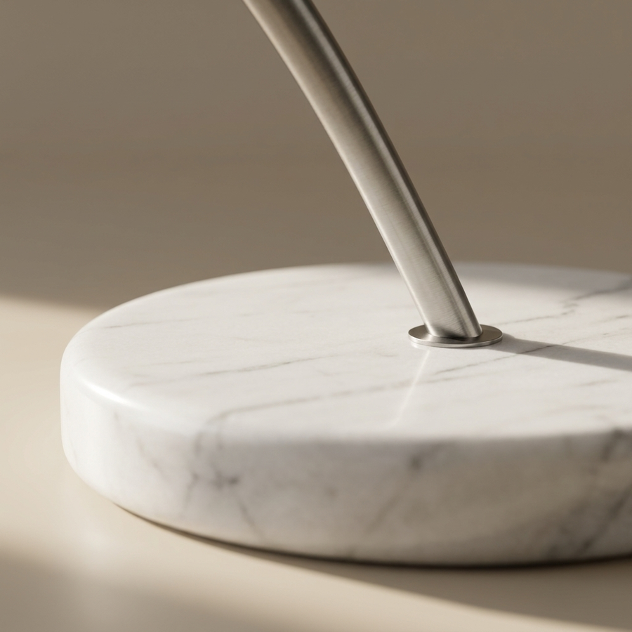 Close-up of the solid marble base of the Bauhaus Arc Floor Lamp where the brushed steel arm meets the stone