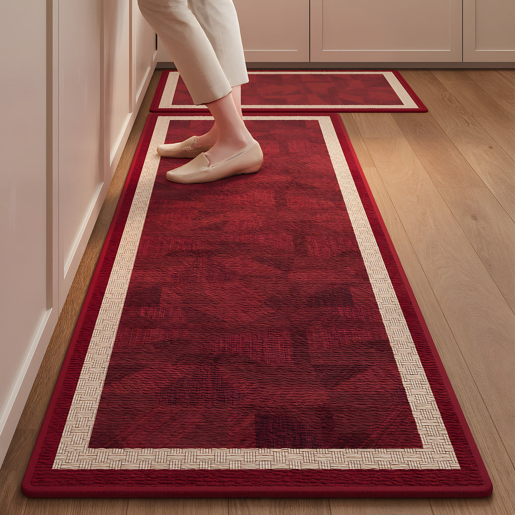Ruby Frame absorbent kitchen mat, deep red centre with a cream frame, on a timber floor