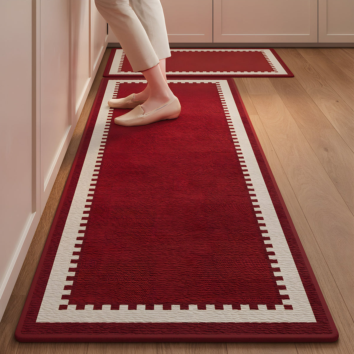 Ruby Step absorbent kitchen mat, deep red centre with a stepped cream border, on a timber floor