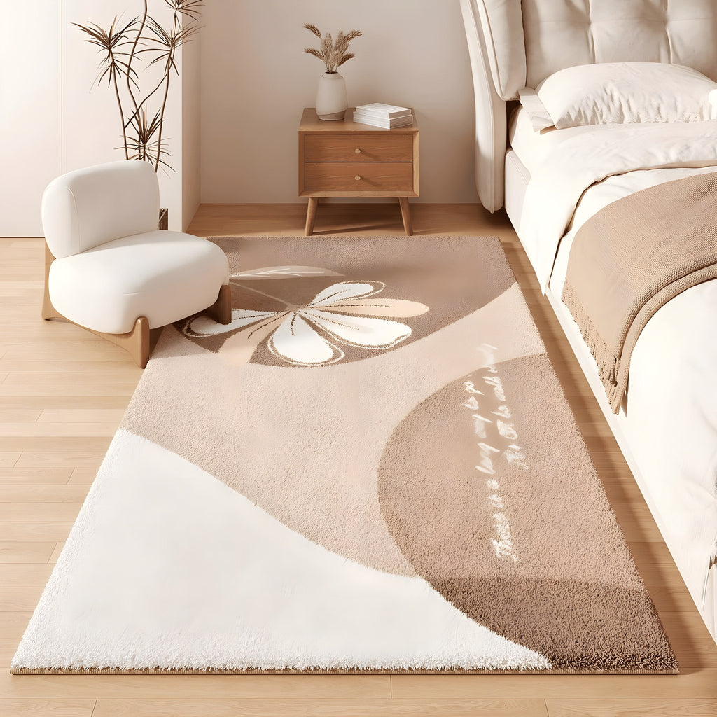 Bloom faux cashmere bedroom rug, cream with a large petal motif, beside a bed
